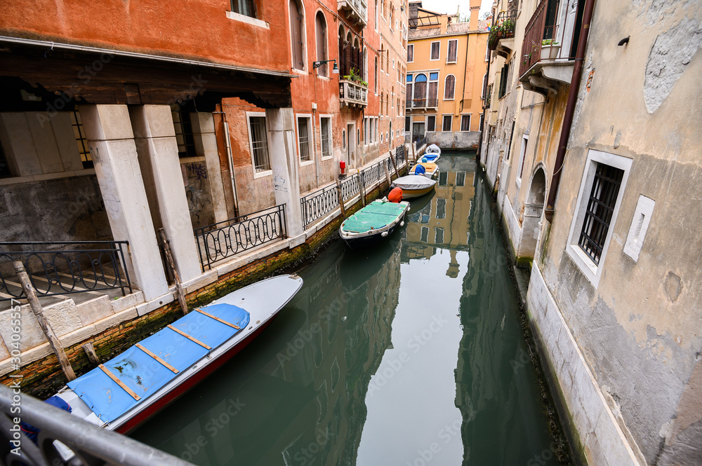 09.10.2019 Venice, Italy, City canal with moored motor boats and gondola.