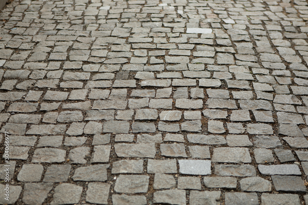 Grey ancient brick road texture background from square stones antique architecture paved footpath for walk 