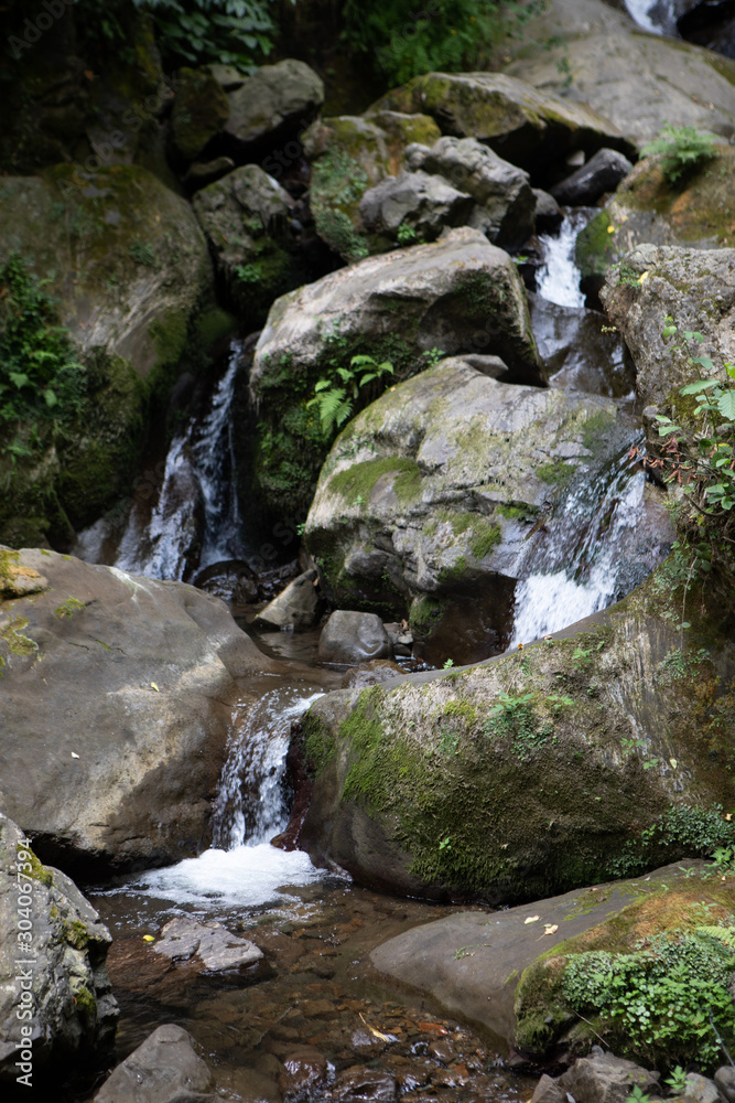 Waterfall among stones inside forest forming stream of fresh water Waterfall among stones inside forest forming stream of fresh water