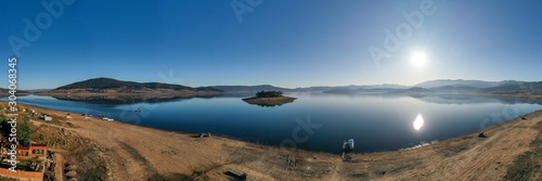 A lonely island between mountain hills with clean blue skies photo