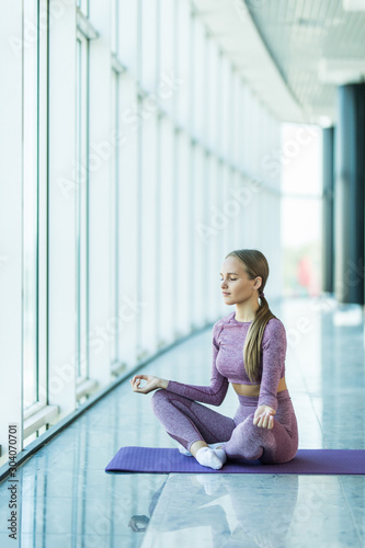 Yoga in studio. Keep calm. Attractive young woman sitting on lotus position on floor with eyes closed. Free Download Yoga in studio. Keep calm. Attractive young woman sitting on lotus position on floor with eyes closed. - GFXLoad