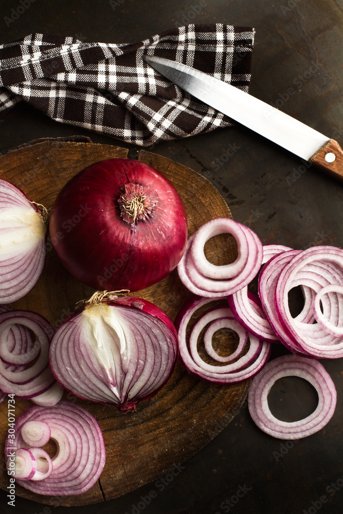 Cebollas cruda morada roja sobre tabla de madera rústica. Vista superior