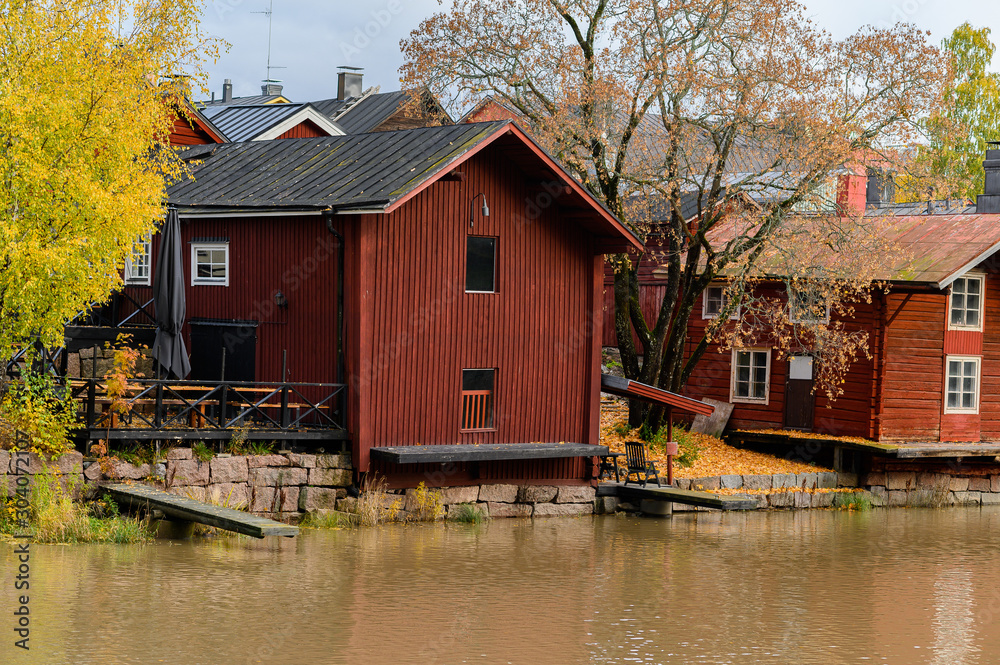Fototapeta The granite embankment with red houses and barns. Beautiful autumn landscape. Historic centre. Porvoo, Finland