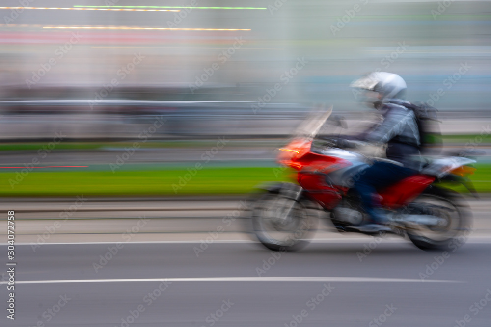 Motorradfahrer mit Bewegungsunschärfe auf der Strasse