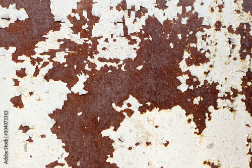 rusty metal wall with cracked white paint, rust through the paint
