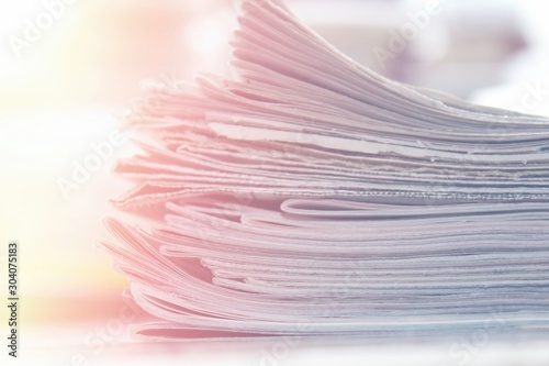 Stack of newspapers close up background, soft light