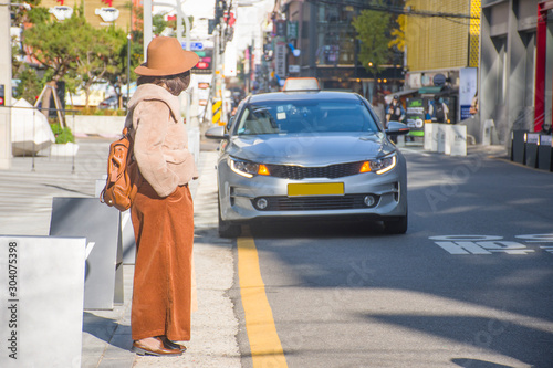 A woman is waiting Taxi in Hongdae, Seoul, South Korea during winter. © BUSARA