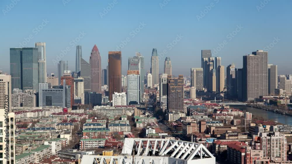 Timelapse modern and old historical Heping District buildings and skyscrapers surround wide calm river under blue sky on sunny day in Tianjin China Timelapse modern and old historical Heping District buildings and skyscrapers surround wide calm river under blue sky on sunny day in Tianjin China