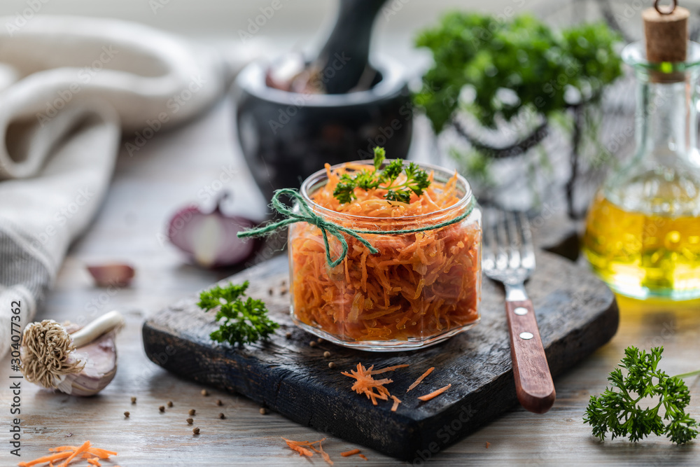 Grated fresh carrot salad with spices in a glass jar Grated fresh carrot salad with spices in a glass jar