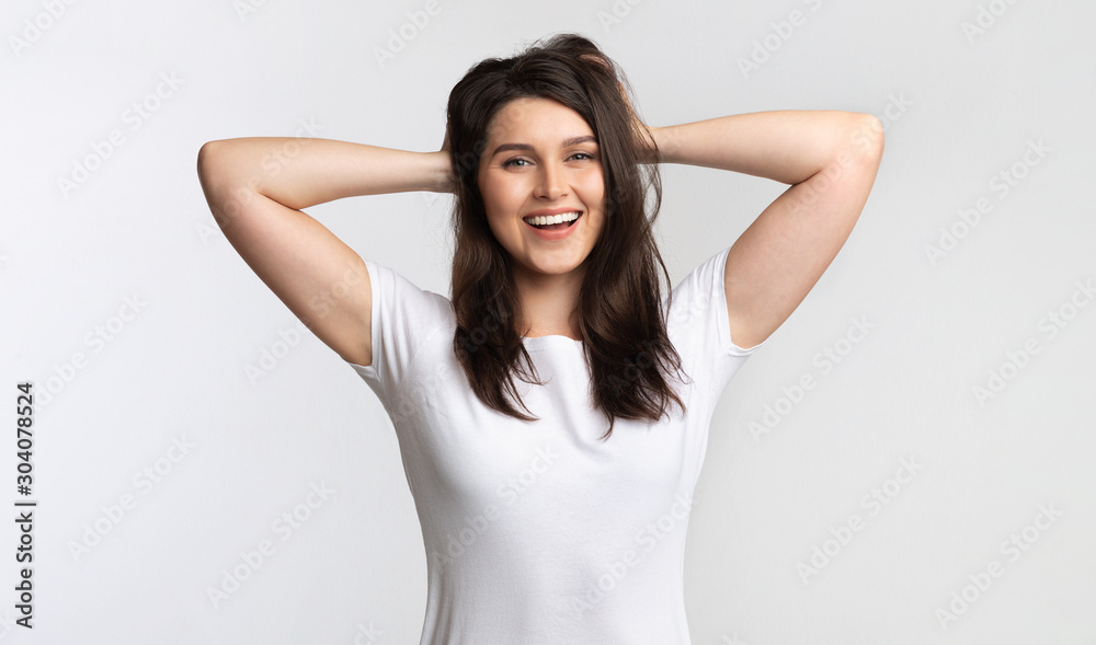 Positive Girl Touching Hair Standing Posing Over White Background, Studio Positive Girl Touching Hair Standing Posing Over White Background, Studio