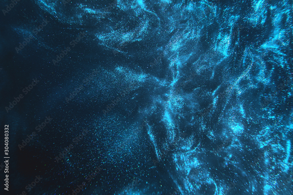 Fototapeta Streszczenie eleganckie, szczegółowe cząsteczki niebieskiego brokatu przepływają z płytką głębią ostrości pod wodą. Wakacyjna magia mieniąca się podwodna przestrzeń luksusu tło. Świąteczne iskierki i światła. zdezorientowany.