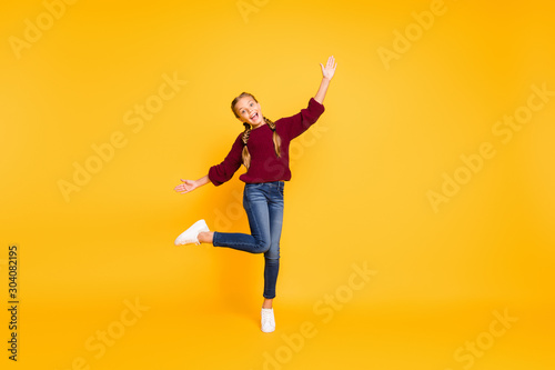 Full length body size view of nice attractive lovely cheerful cheery girlish carefree careless pre-teen girl having fun dancing isolated over bright vivid shine vibrant yellow color background © deagreez