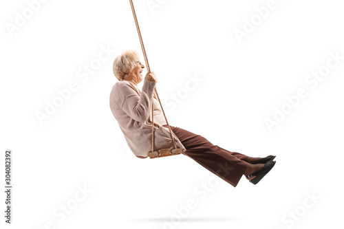 Elderly lady enjoying on a wooden swing