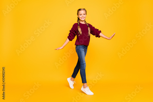 Full length body size view of nice attractive charming lovely cheerful cheery girlish carefree pre-teen girl strolling isolated over bright vivid shine vibrant yellow color background
