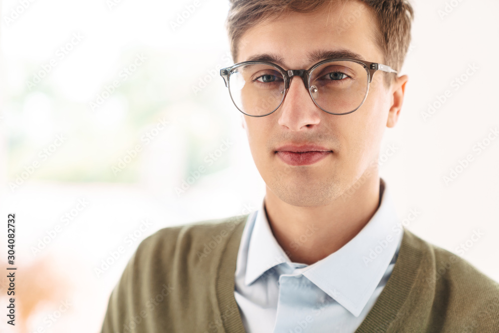 Serious young guy student posing indoor in eyeglasses. Serious young guy student posing indoor in eyeglasses.