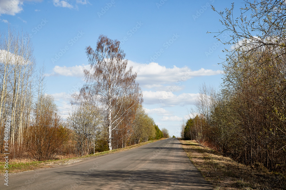 Nature landscape with road, blue sky and white clouds in a spring or autumn day. Travel and Journey concept Nature landscape with road, blue sky and white clouds in a spring or autumn day. Travel and Journey concept