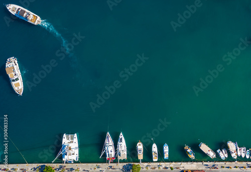 Aerial drone bird's eye top view of white traditional fishing boat in turquoise clear waters, Simy, Greece photo