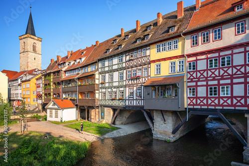 Classic panoramic view of ancient city center of Erfurt with famous Krämerbrücke bridge, colorful houses and historic St Giles' Church on a sunny day with blue sky in summer, Thuringia, Germany