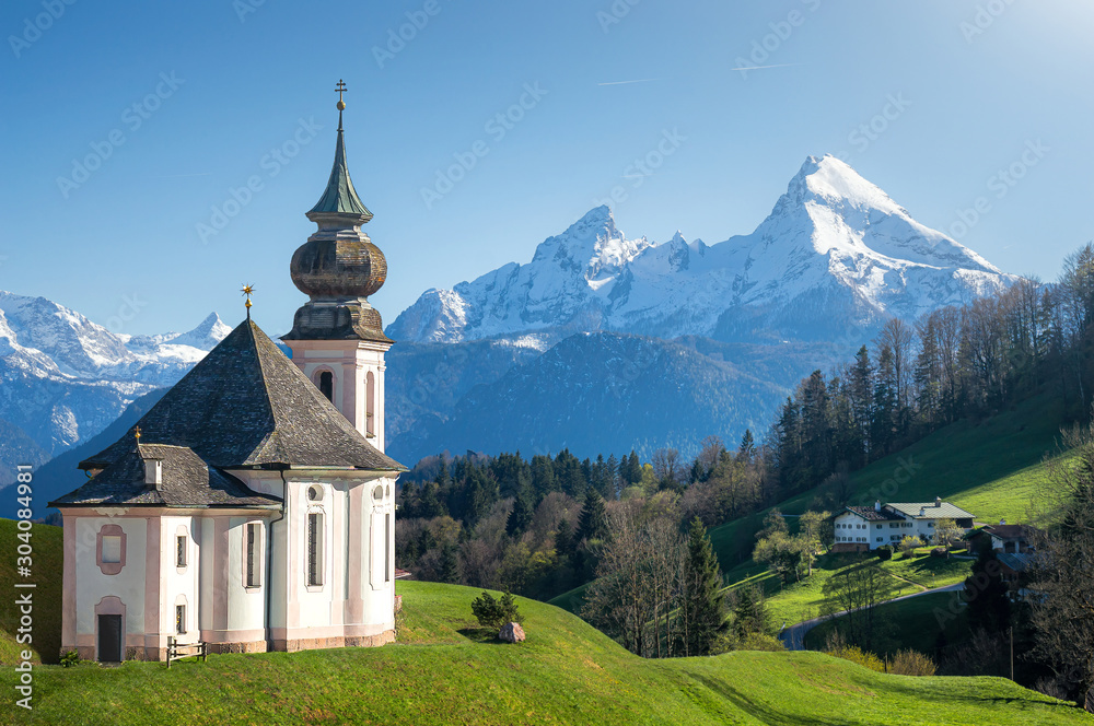 Classic panoramic view of scenic snow-capped Watzmann mountain top with historic pilgrimage church Maria Gern on a beautiful sunny day in spring, Nationalpark Berchtesgadener Land, Bavaria, Germany Classic panoramic view of scenic snow-capped Watzmann mountain top with historic pilgrimage church Maria Gern on a beautiful sunny day in spring, Nationalpark Berchtesgadener Land, Bavaria, Germany