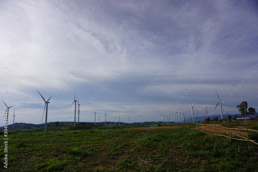 The image of a remote turbine in a green background, a blue background consisting of floating clouds and sunlight shining down. The image of a remote turbine in a green background, a blue background consisting of floating clouds and sunlight shining down.