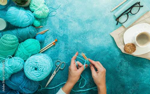 Yarn for knitting mint, blue, green, turquoise and knitting needles. Aquamarine background. Heart made of yarn. photo