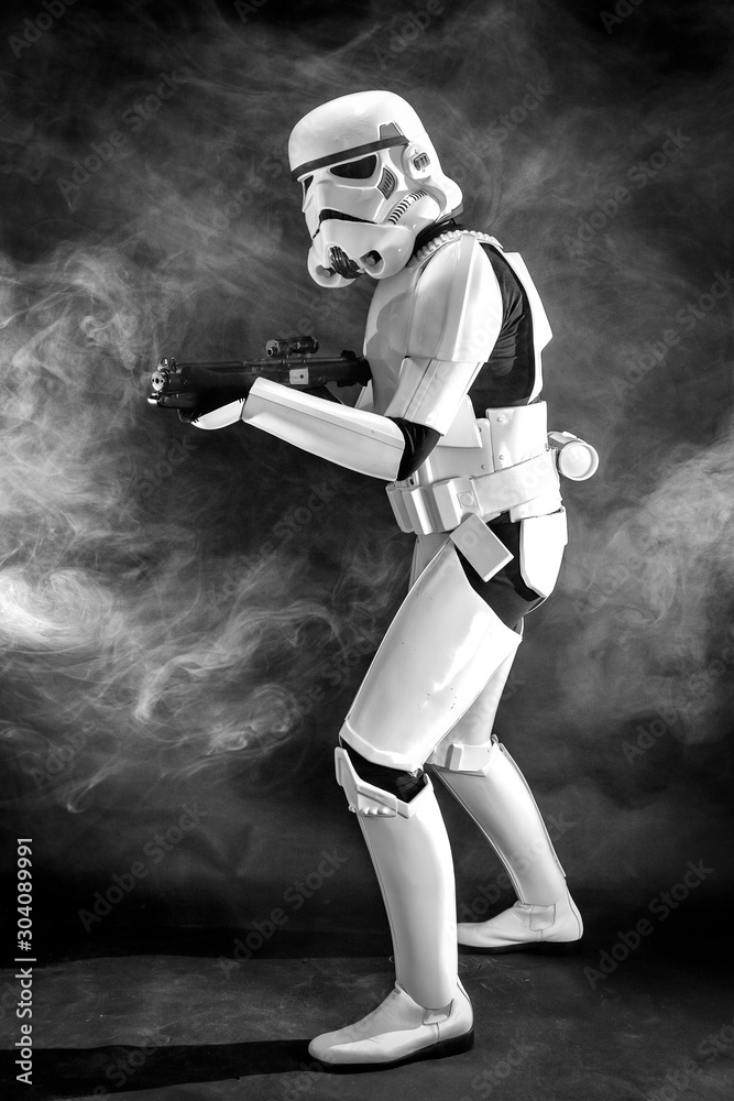 SAN BENEDETTO DEL TRONTO, ITALY. NOVEMBER 11, 2017. Studio portrait of stormtrooper  costume replica, with blaster E-11 gun. He is a fictional character of Star  Wars saga. Black background with smoke Stock