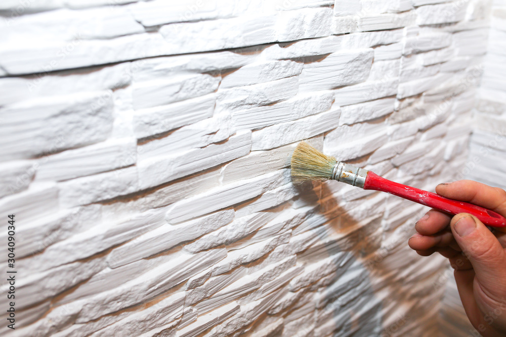 Fotografie Man is painting wall with brush