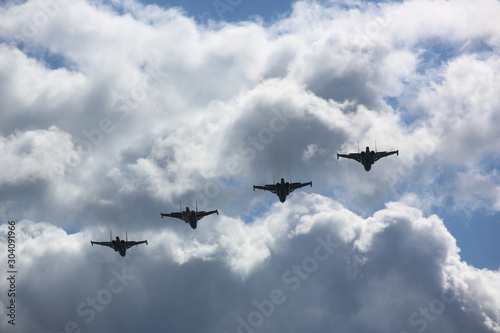 Group of military aircrafts flying in blue sky. Fast warplane jets designed for attacking other armed exterminator. Hostilities or martial parade concept