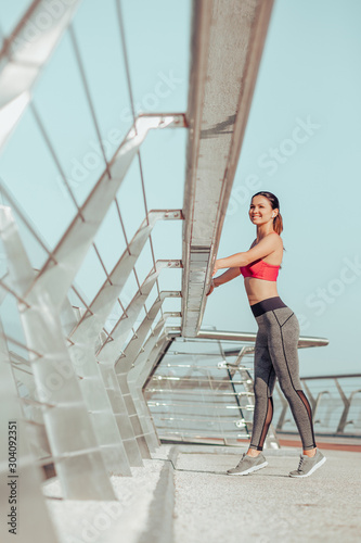 full length shot of female athlete standing on the bridge alone