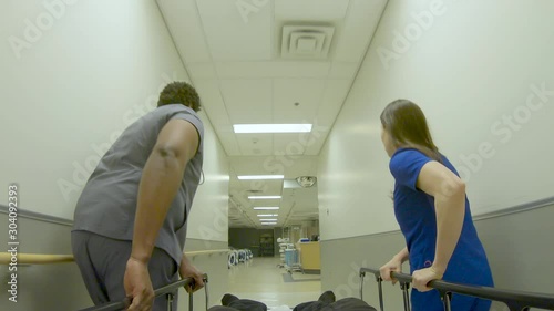 Patient's point of view in a gurney being wheeled through the hospital by worried nurses. photo