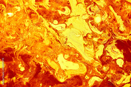Abstract golden orange background. Flashes in the sun, liquid fire. Flowing lava colors paint photo