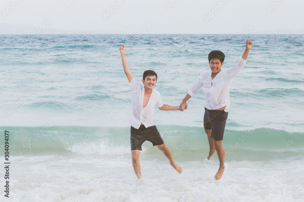 Homosexual portrait young asian couple running and jump with cheerful together on beach in summer, asia gay going tourism for leisure and relax with happiness in vacation at sea, LGBT legal concept. Homosexual portrait young asian couple running and jump with cheerful together on beach in summer, asia gay going tourism for leisure and relax with happiness in vacation at sea, LGBT legal concept.