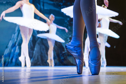 Fototapeta Legs of ballerinas dancing in ballet Swan Lake.