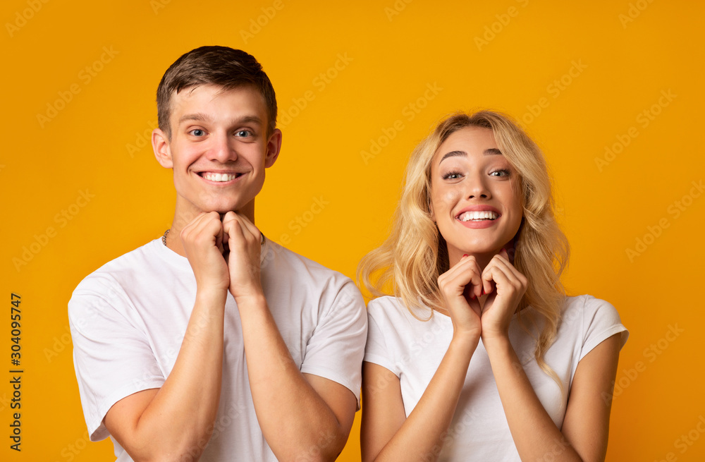 Young guy and girl pleading for something with clasped hands Young guy and girl pleading for something with clasped hands