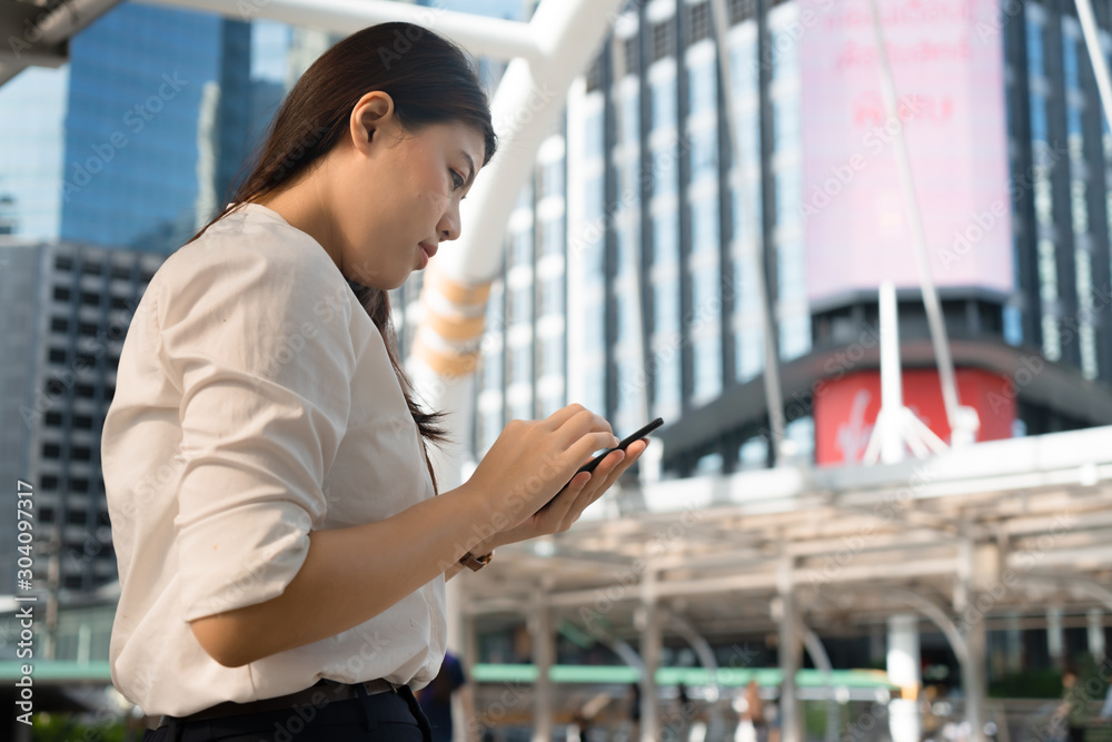 Professional business woman smiling use smartphone chat working to outdoor city. Professional business woman smiling use smartphone chat working to outdoor city.