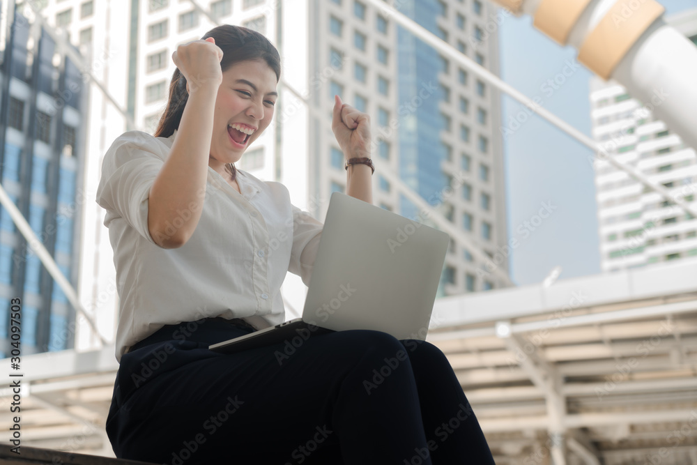 Asian businesswoman is sitting happily and successfully working with a laptop. Asian businesswoman is sitting happily and successfully working with a laptop.