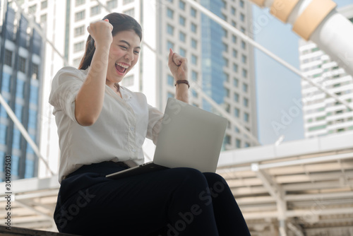 Asian businesswoman is sitting happily and successfully working with a laptop. Free Download Asian businesswoman is sitting happily and successfully working with a laptop. - GFXLoad