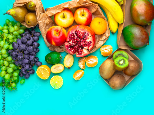 Fototapeta Naklejka Na Ścianę i Meble -  Fruits and vegetables rich in antioxidants, vitamin and fiber on blue background. Zero waste food shopping, eco natural paper bags Flat lay style