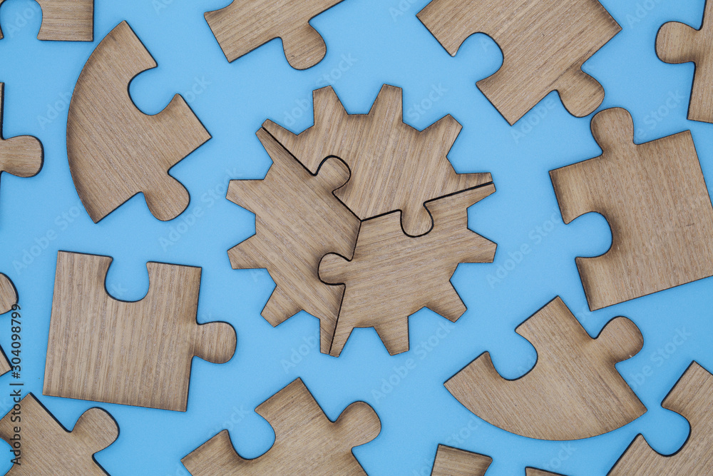 Wooden jigsaw puzzle on a blue background Wooden jigsaw puzzle on a blue background