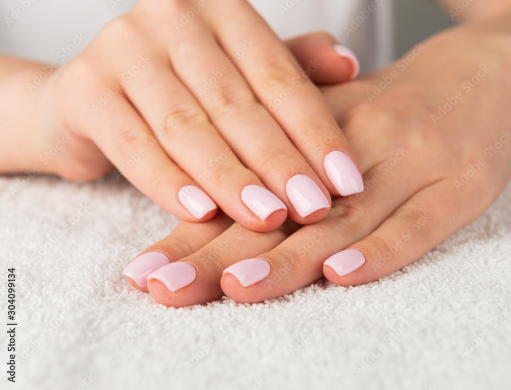 Beautiful female hand with light pink nail design.. Beautiful female hand with light pink nail design..
