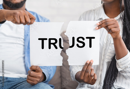 Black man and woman ripping paper with trust inscription