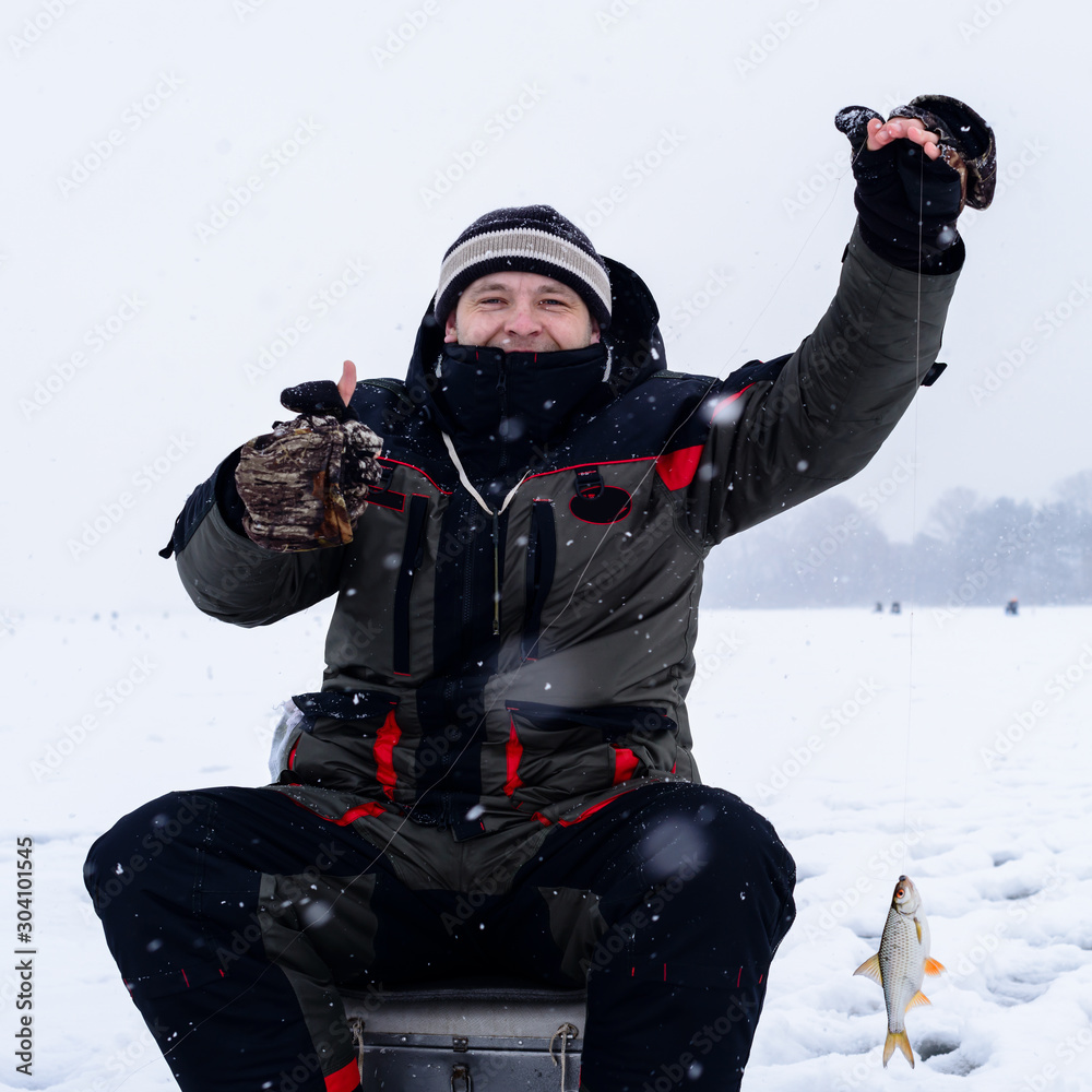 Happy smiling adult fisherman showing thumbs up after successful Happy smiling adult fisherman showing thumbs up after successful