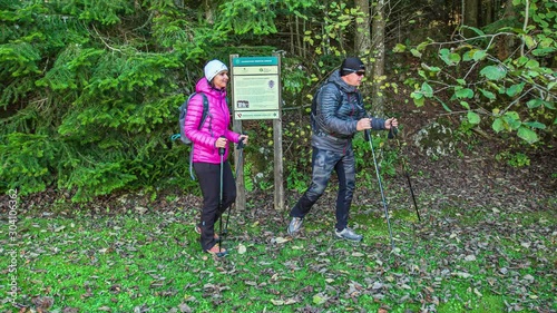 Hikers stand by information board about Masun, walk away, continue journey photo