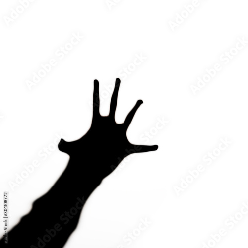 Black silhouette of human hand with spread fingers stretches like in horrors