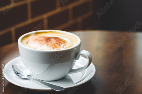 Fototapeta Naklejka Na Ścianę i Meble -  close up modern hot black coffee the cappuccino on wood background with coffee bubble foam pattern and texture in white cup looking and feel so delicious on glasses table in coffee shop.