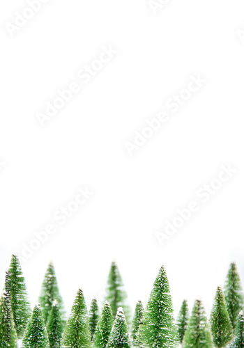 Vertical image of Winter landscape group miniature set model winter pine tree with snow is props decoration for create atmosphere festival Christmas. isolated on white background and copy space.