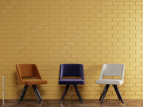 3 different chairs in modern style standing in front of yellow brick wall with copy space