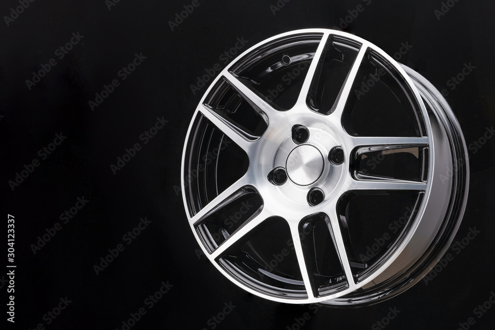 Obraz premium car cast aluminum alloy wheels, black silver with polished front, very beautiful and modern, fashion. Close-up on dark background, elements, spokes.