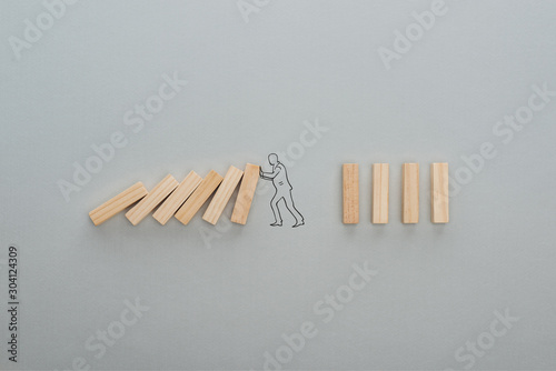 top view of drawn man pushing wooden blocks on grey background  business concept