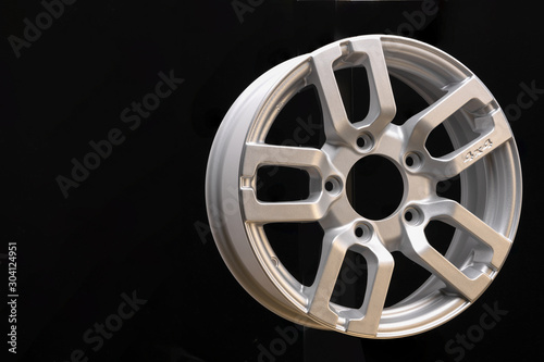 car cast aluminum alloy wheels, black silver with polished front, very beautiful and modern, fashion. Close-up on dark background, elements, spokes.